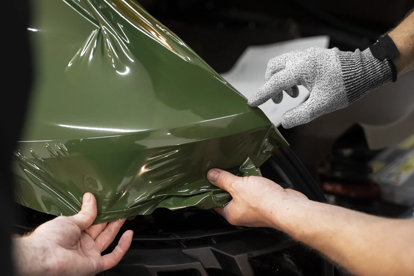 Applicazione di pellicola protettiva su auto verde